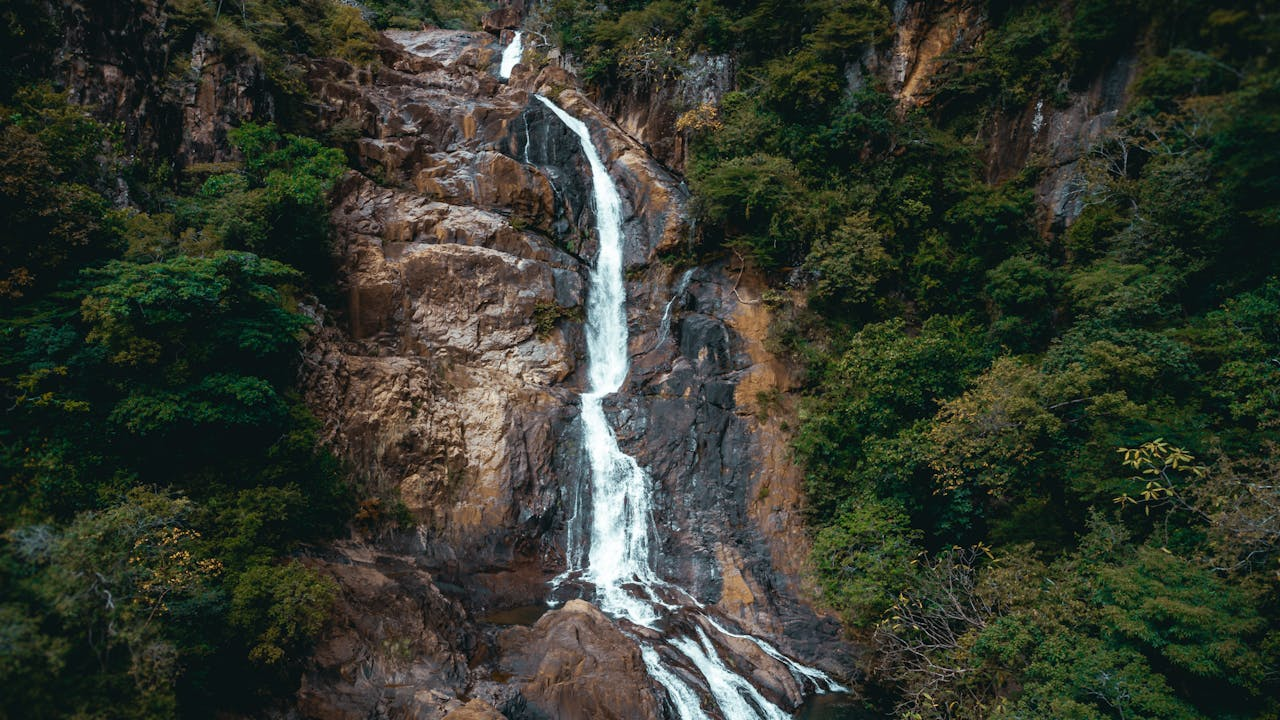 A breathtaking waterfall cascades down rocky cliffs surrounded by dense tropical forest in Coclé Province, Panama.